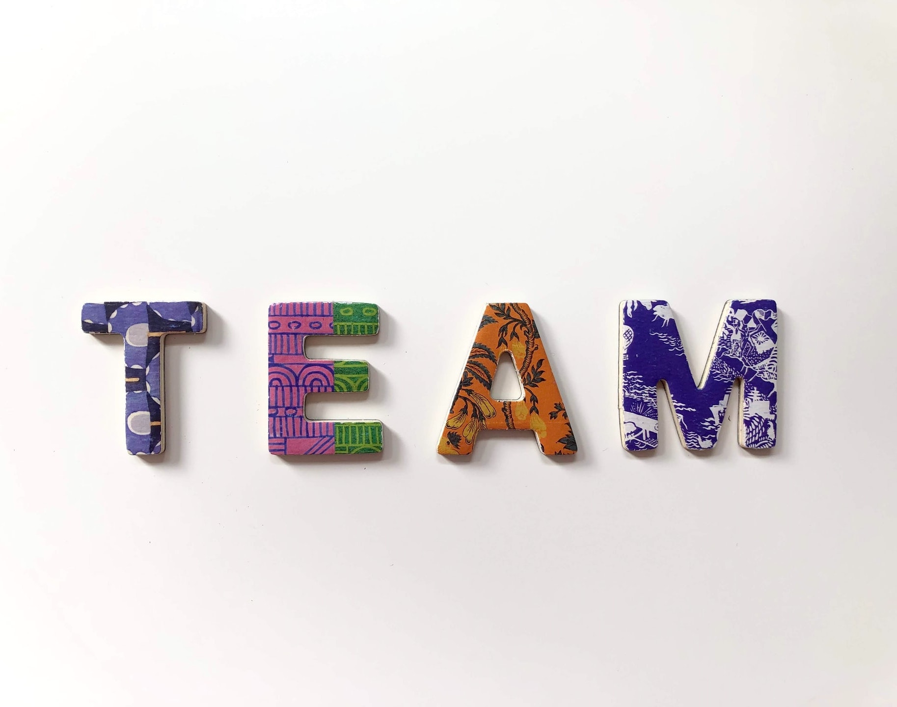 Bunte Buchstaben bilden das Wort Team auf einem weißen Hintergrund